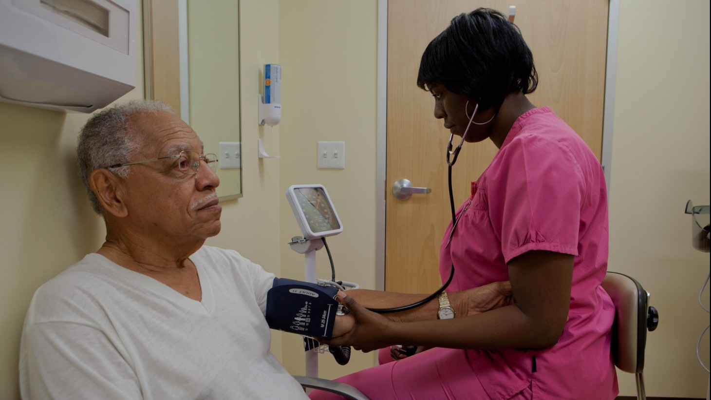 Nurse checking a elderly man's blood pressure 