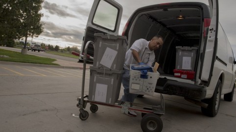 Courier loading the back of a van with packages
