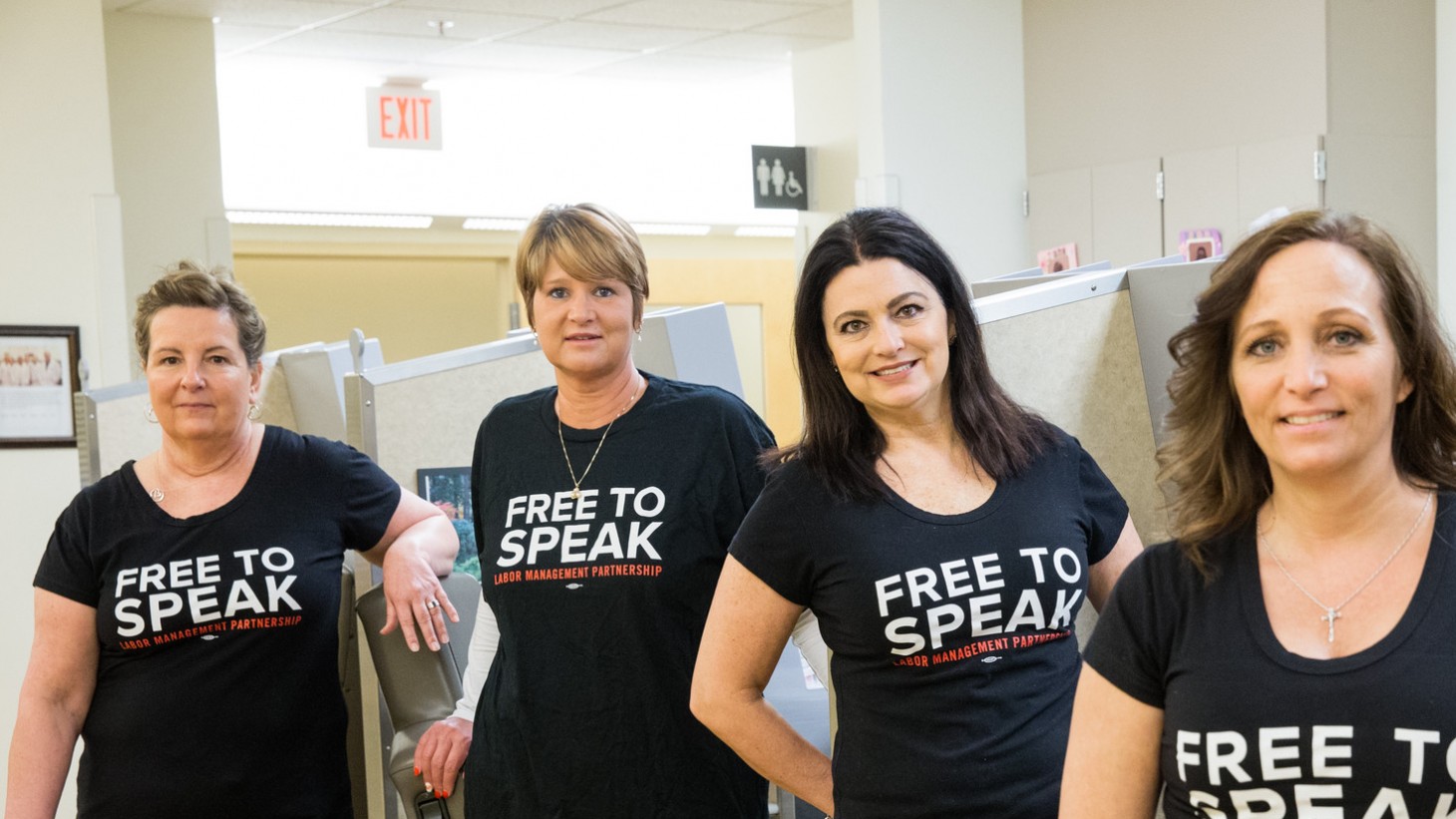 4 women wearing black Free to Speak t-shirts 
