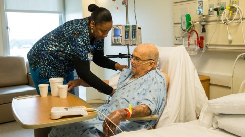 Caregiver with elderly patient in a hospital room 