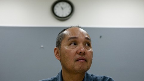 Anxious-looking man sitting under a clock 