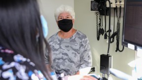 Elderly female patient in a doctor's office, wearing a mask