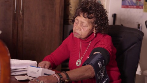 Elderly woman checks her blood pressure in her own home 